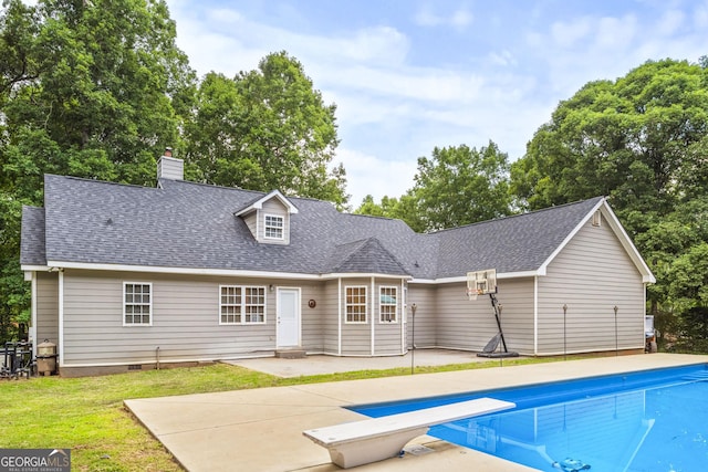 back of property with a lawn and a patio