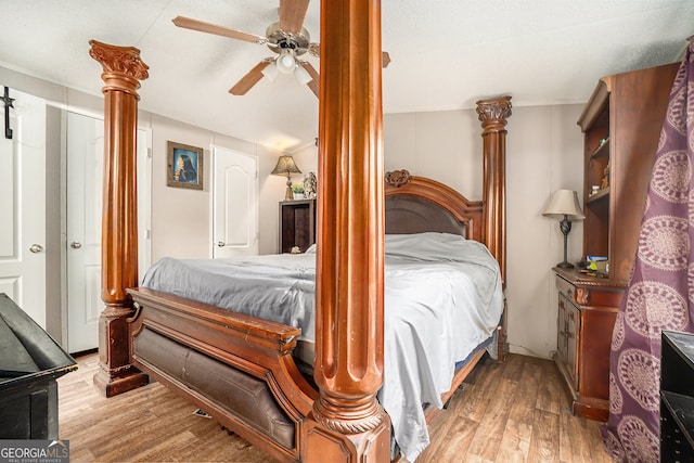 bedroom with a textured ceiling, light wood-type flooring, ceiling fan, and lofted ceiling