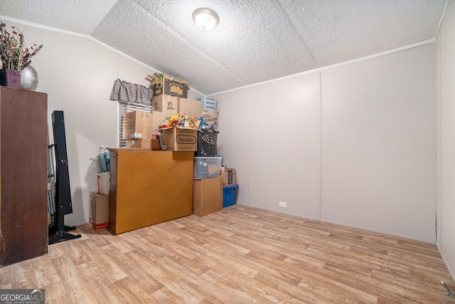 additional living space featuring a textured ceiling, lofted ceiling, and light wood-type flooring