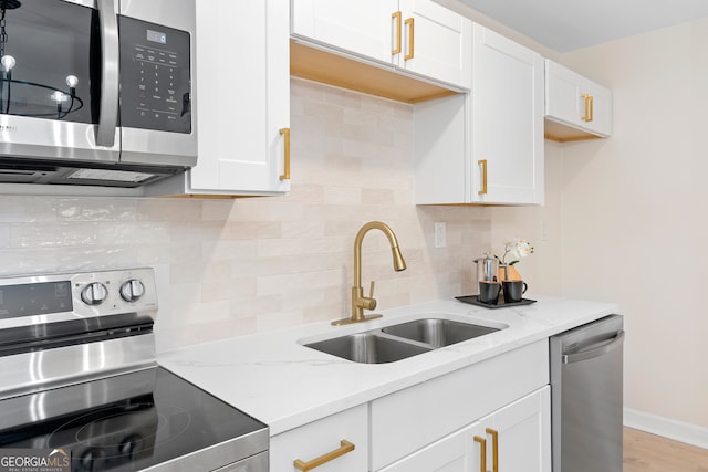 kitchen featuring white cabinets, sink, appliances with stainless steel finishes, and tasteful backsplash