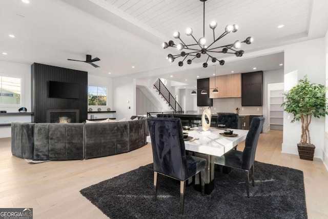 dining space featuring a wealth of natural light, light hardwood / wood-style flooring, and ceiling fan with notable chandelier