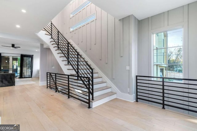 staircase featuring plenty of natural light, ceiling fan, and wood-type flooring