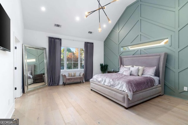 bedroom with light hardwood / wood-style flooring and a notable chandelier