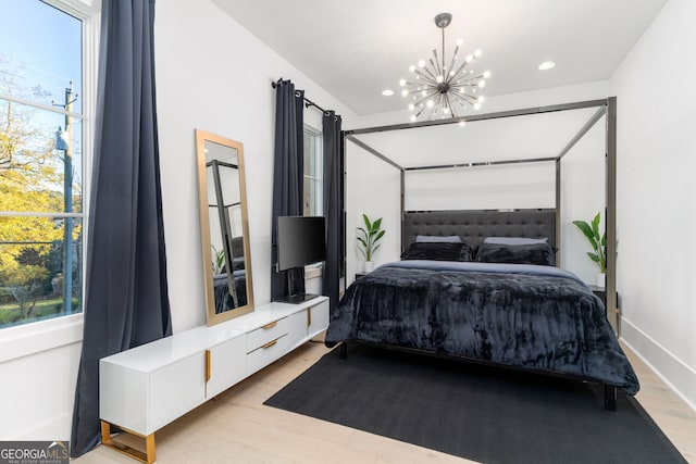 bedroom with a chandelier and light hardwood / wood-style floors