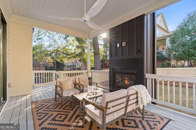 wooden terrace featuring an outdoor living space with a fireplace and ceiling fan