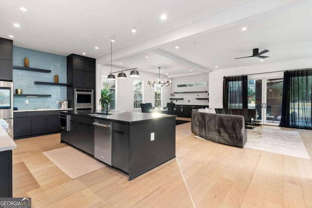 kitchen featuring sink, a spacious island, decorative light fixtures, light hardwood / wood-style floors, and ceiling fan with notable chandelier