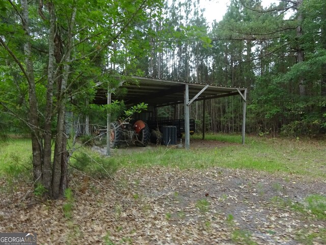 view of yard featuring a carport and central air condition unit