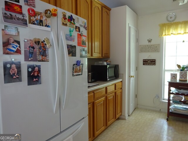 kitchen with white refrigerator and a wealth of natural light