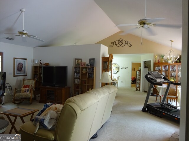 living room featuring light carpet, ceiling fan with notable chandelier, and vaulted ceiling