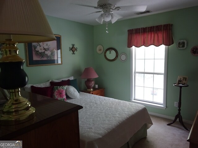 carpeted bedroom with ceiling fan and multiple windows