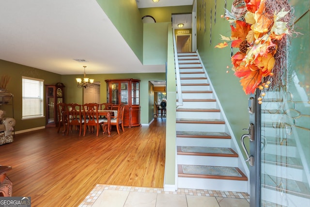 staircase featuring hardwood / wood-style flooring and a notable chandelier