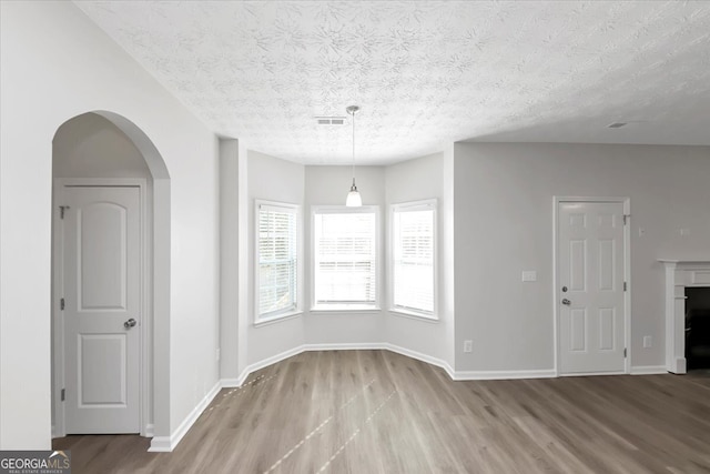 empty room featuring a textured ceiling and light wood-type flooring