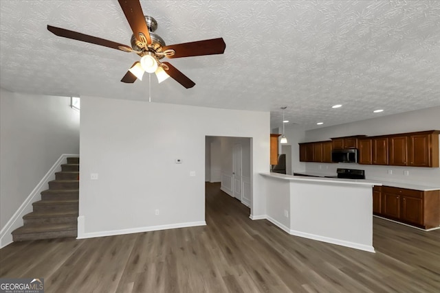 kitchen with ceiling fan, black range oven, dark wood-type flooring, decorative light fixtures, and a textured ceiling