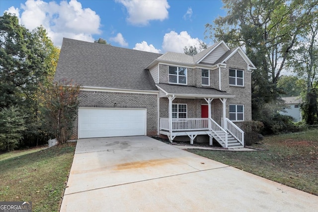 front facade with covered porch, a garage, and a front yard