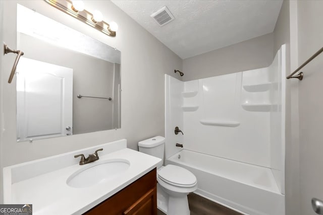 full bathroom with tub / shower combination, vanity, a textured ceiling, hardwood / wood-style flooring, and toilet