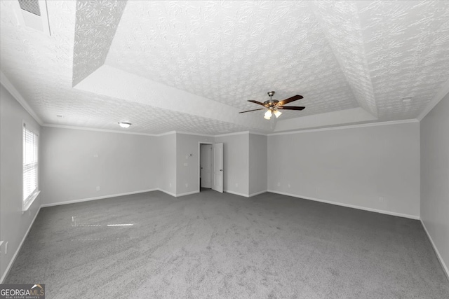 interior space featuring ceiling fan, crown molding, a textured ceiling, and a tray ceiling