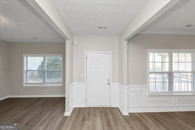 foyer entrance with plenty of natural light, hardwood / wood-style floors, and a textured ceiling