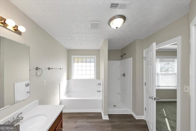 bathroom featuring separate shower and tub, vanity, a textured ceiling, and hardwood / wood-style flooring