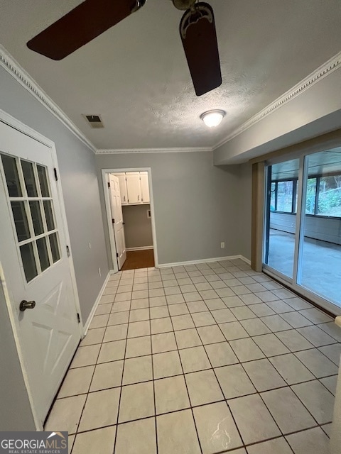 tiled empty room featuring crown molding and a textured ceiling