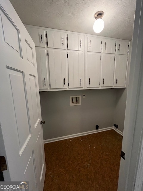 laundry area featuring cabinets, washer hookup, a textured ceiling, and dark carpet