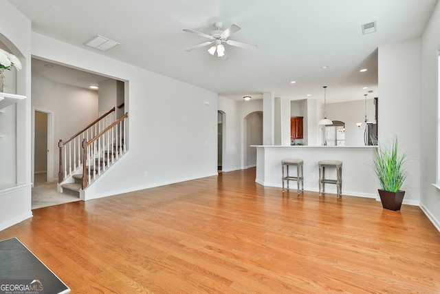 unfurnished living room featuring ceiling fan and light hardwood / wood-style floors