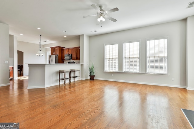 living room featuring ceiling fan and light hardwood / wood-style flooring