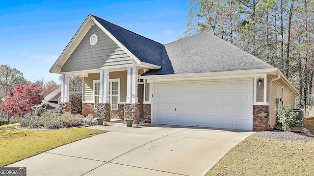 craftsman-style home with cooling unit, a front lawn, covered porch, and a garage