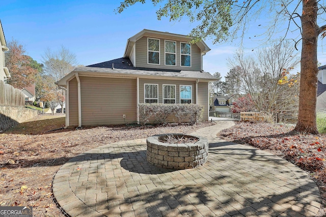 rear view of property with a patio area and a fire pit