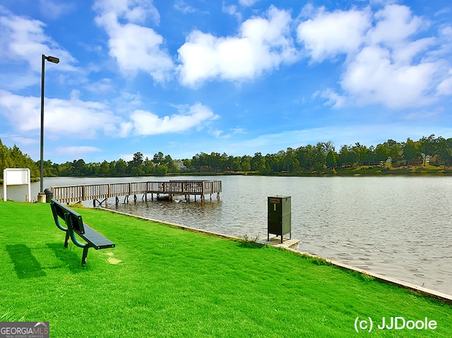 dock area with a lawn and a water view