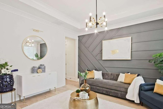 living room featuring wooden walls, light hardwood / wood-style flooring, ornamental molding, and an inviting chandelier