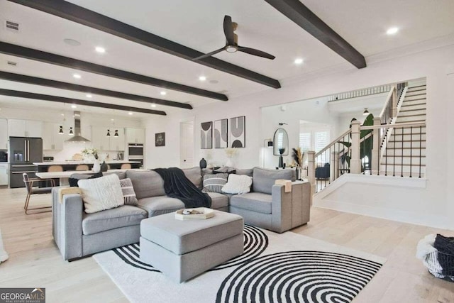 living room featuring beam ceiling, light wood-type flooring, and ceiling fan