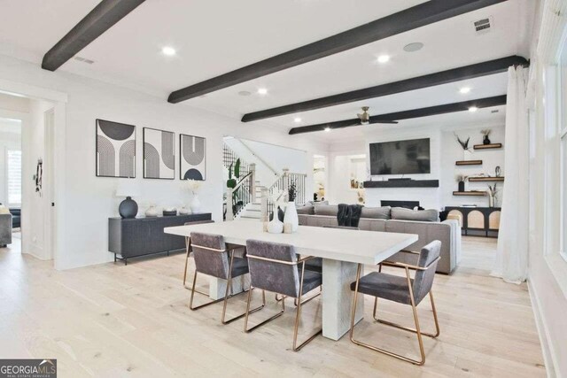 dining space with beam ceiling, ceiling fan, and light wood-type flooring