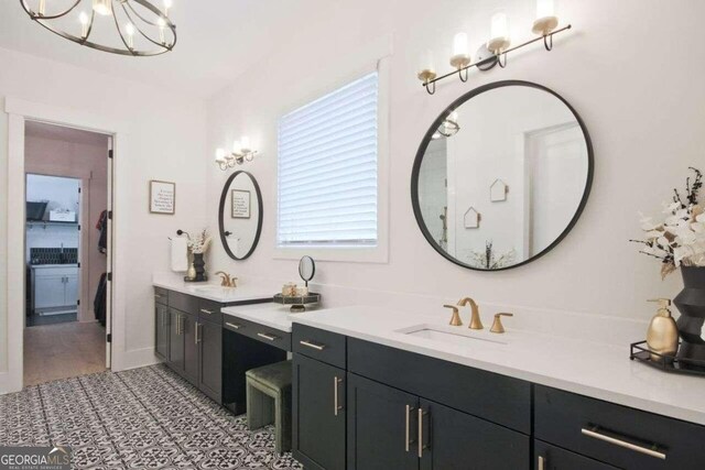 bathroom with a chandelier, vanity, and tile patterned flooring