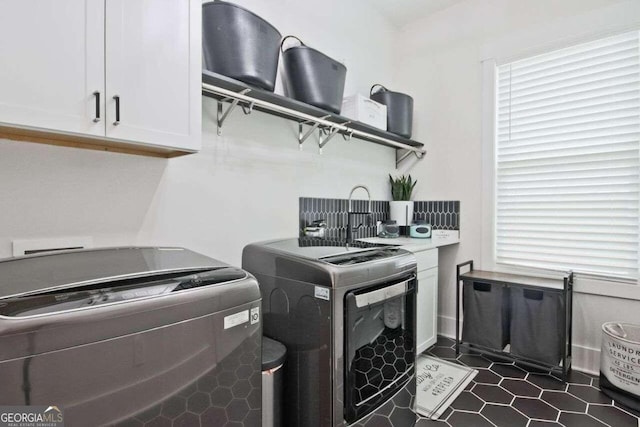 laundry area with cabinets and washer and clothes dryer