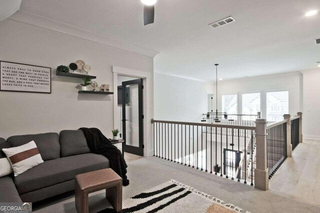 hallway featuring crown molding and light hardwood / wood-style flooring