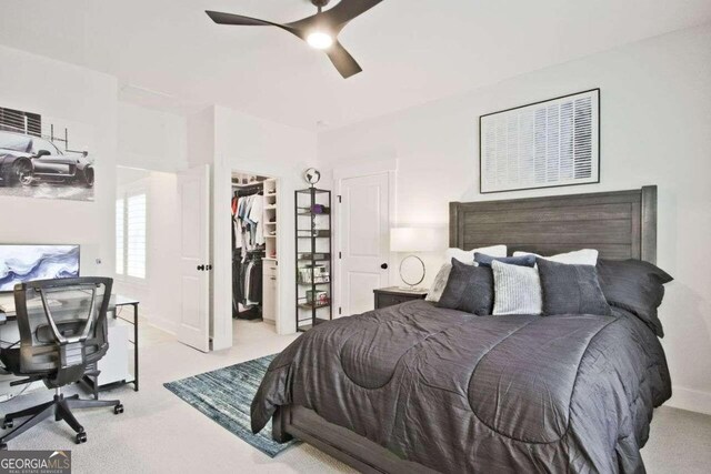 bedroom featuring ceiling fan, a closet, light colored carpet, and a spacious closet