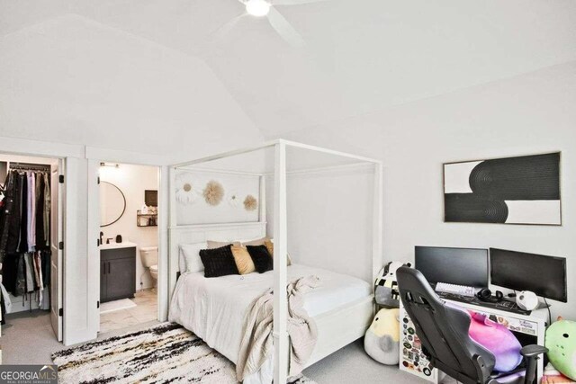 bedroom with lofted ceiling, ensuite bath, ceiling fan, light colored carpet, and a closet