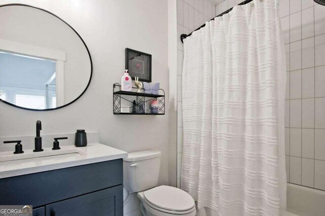 full bathroom featuring shower / bathtub combination with curtain, vanity, and toilet