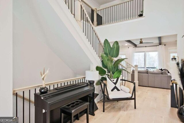 interior space featuring hardwood / wood-style flooring, ceiling fan, and a high ceiling