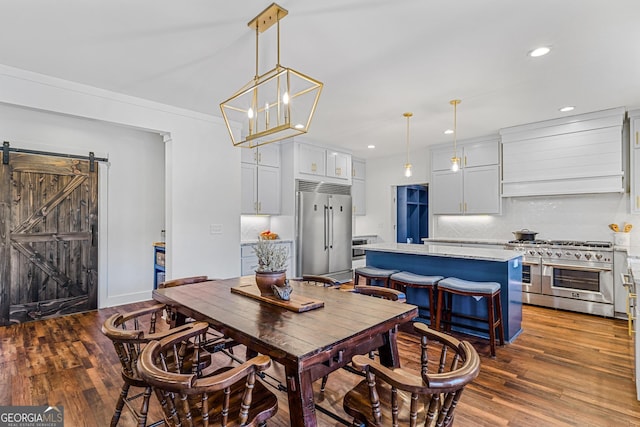 dining space featuring a barn door and dark hardwood / wood-style floors