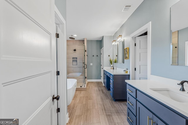 bathroom featuring shower with separate bathtub and vanity