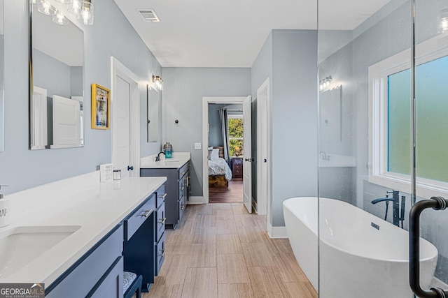 bathroom with hardwood / wood-style flooring, vanity, and a bath