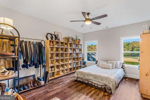 bedroom featuring dark hardwood / wood-style flooring, multiple windows, and ceiling fan