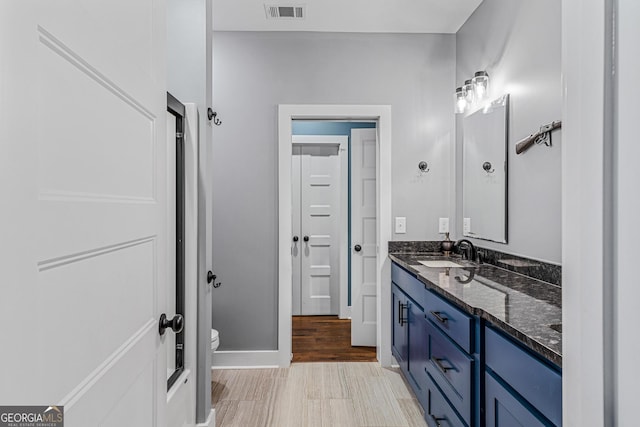 bathroom featuring hardwood / wood-style floors, vanity, and toilet