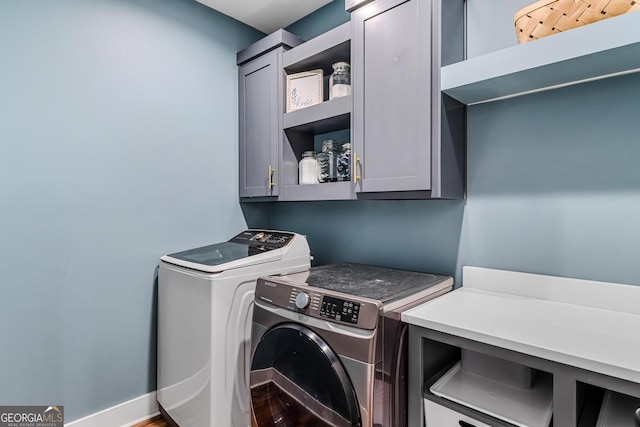 washroom with washing machine and dryer and cabinets