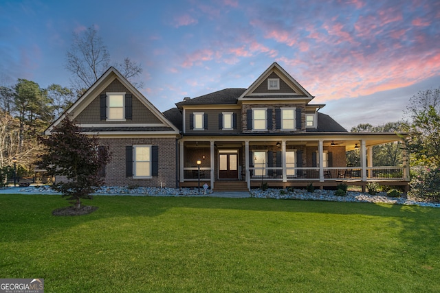 view of front of house featuring covered porch, ceiling fan, and a lawn