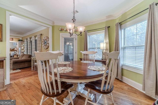 dining room featuring crown molding, a chandelier, and light wood-type flooring