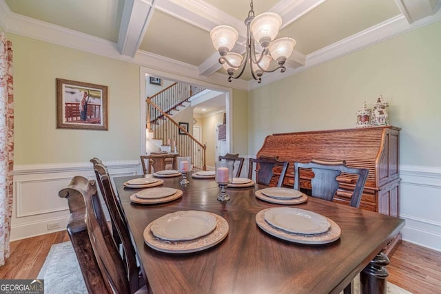 dining area with a chandelier, beamed ceiling, light hardwood / wood-style flooring, and ornamental molding