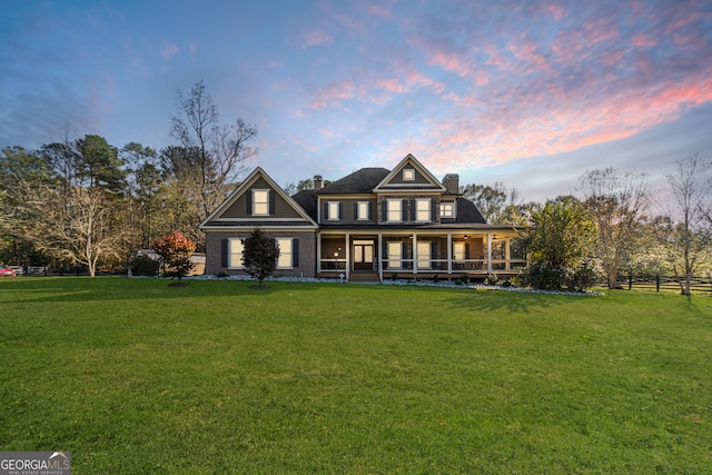 view of front of property featuring a porch and a lawn