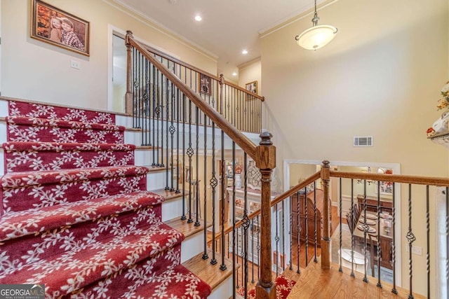 stairs featuring hardwood / wood-style floors and crown molding